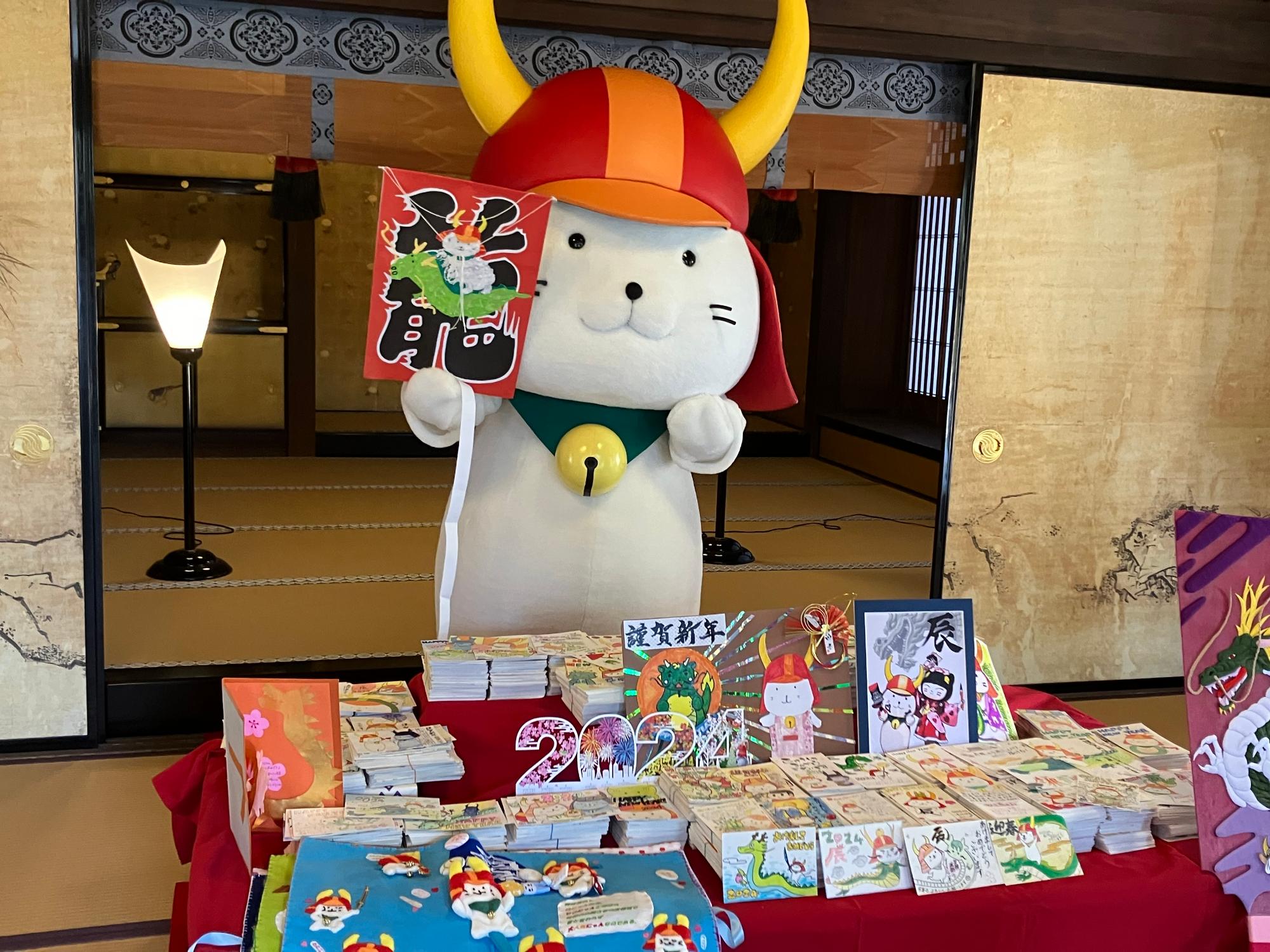 たくさんの年賀状を前に喜ぶひこにゃんの写真