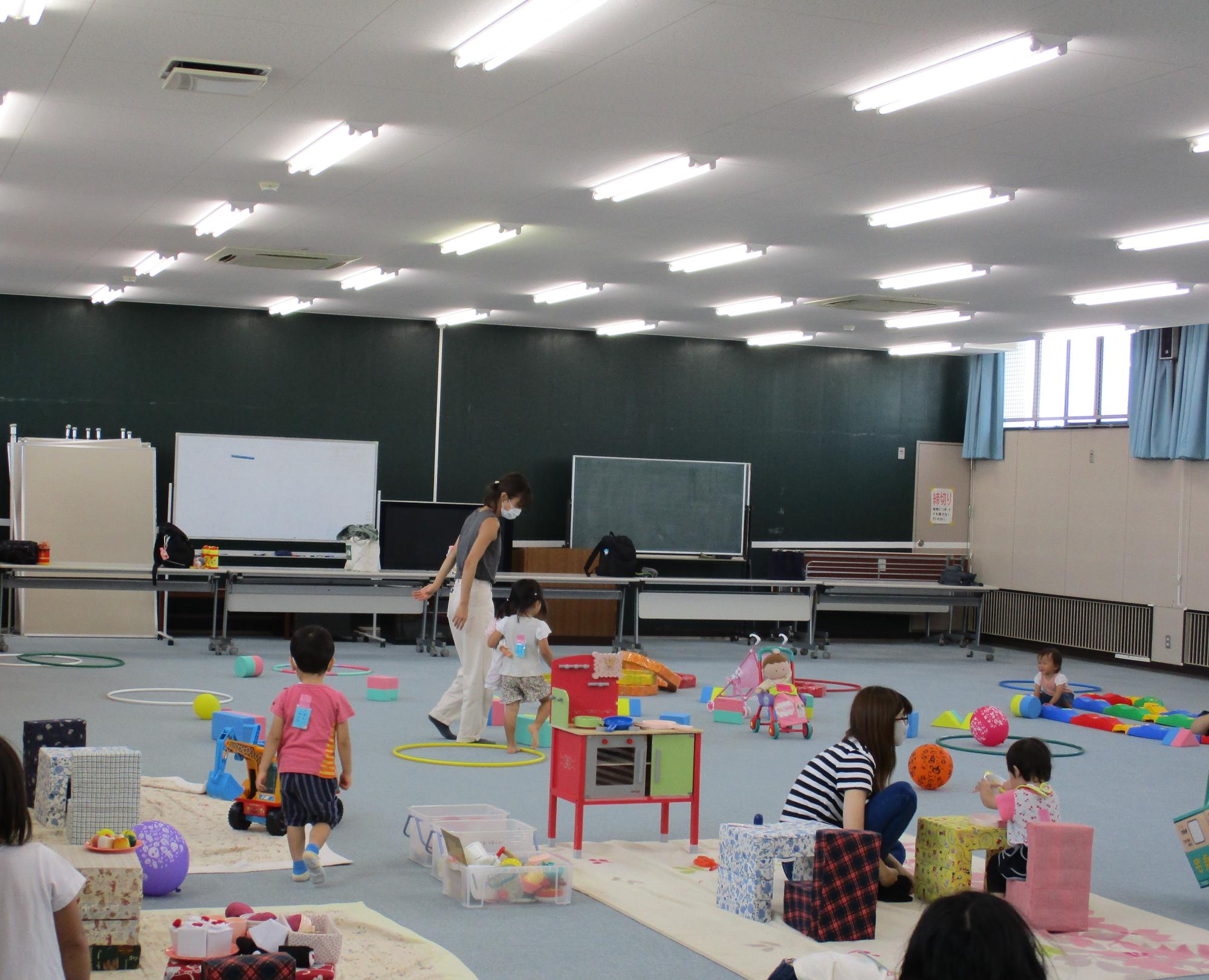 ひまわりひろばの様子(玩具が広がった室内で遊ぶ複数の親子)