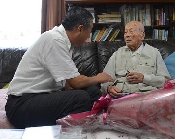 最高齢者と歓談している市長の写真