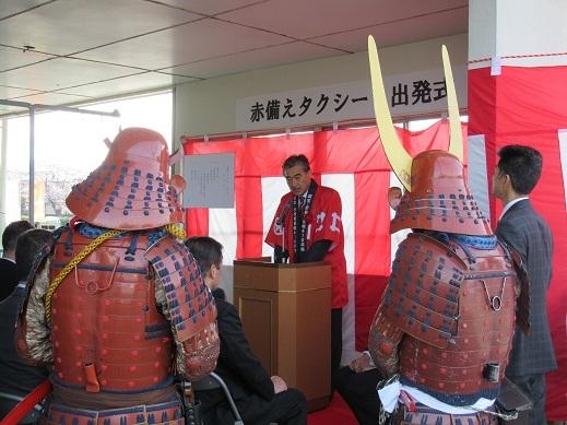 赤備えタクシー出発式であいさつをしている市長の写真