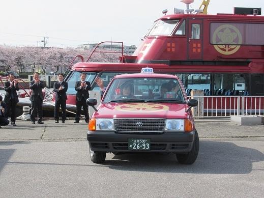赤備えタクシーの出発を見送っている写真