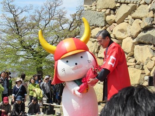 市長からお祝いの花束を受け取っているひこにゃんの写真