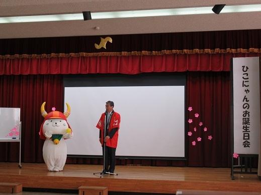 後方から撮影した「ひこにゃんファンクラブの集い」であいさつしている市長の写真