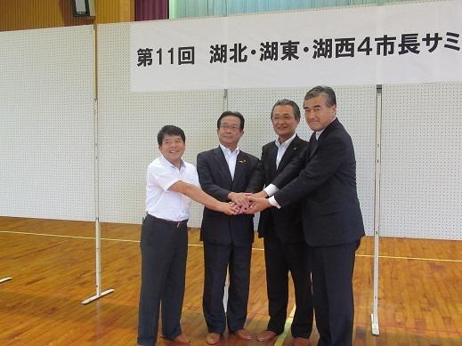 4市長が手を合わせて記念撮影をしている写真