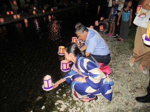 川に万灯を流している市長の写真