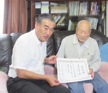 最高齢者に認定書を渡している市長の写真