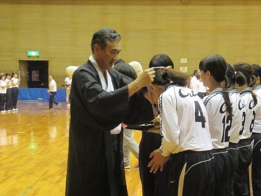 優勝選手の首にメダルをかけている市長の写真