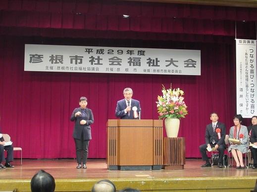 彦根市社会福祉大会と手話で通訳をしている女性の写真