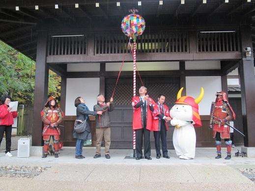 彦根城70万人目来場者と共にくす玉割をしている市長の写真