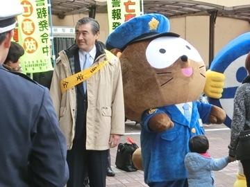 交通安全のタスキをかけて街頭啓発をしている市長の写真