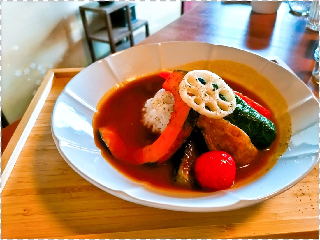 大きな野菜が乗ったヴィ―ガンカレーの写真