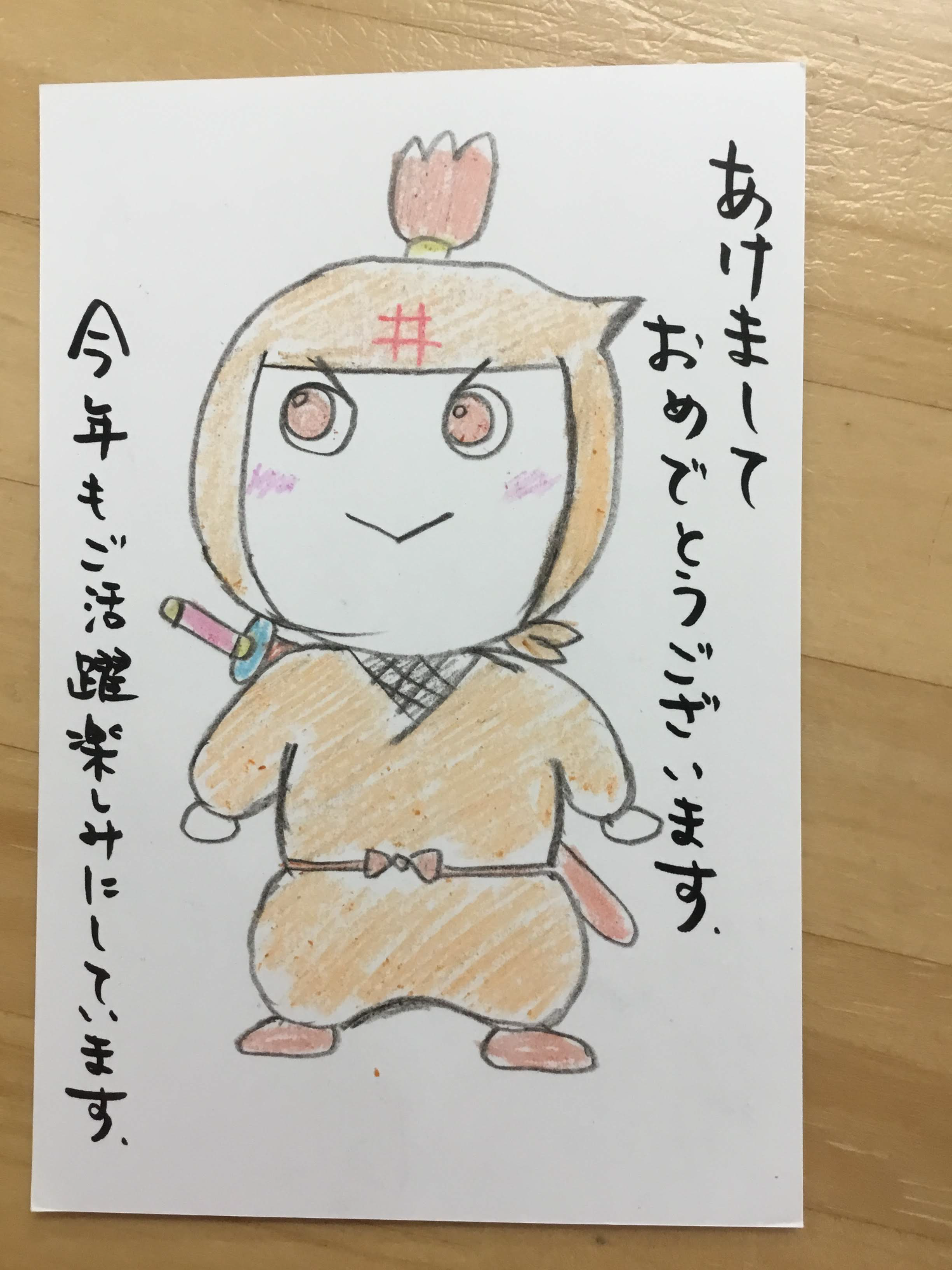 あけましておめでとうございます。今年もご活躍楽しみにしています。と書かれた年賀状の写真