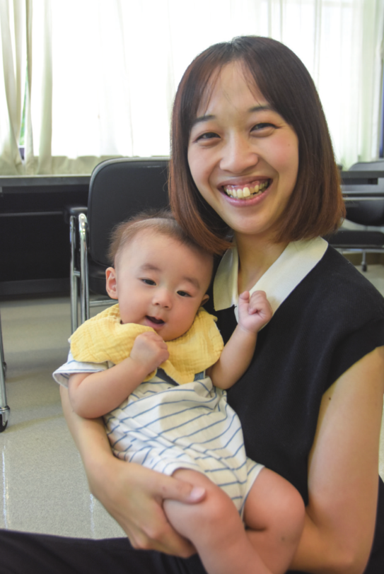 笑顔のお母さんとお母さんに抱っこされる赤ちゃんの写真