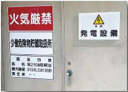 発電設備があり、「火気厳禁」「少量危険物貯蔵取扱書」などと記載がある扉