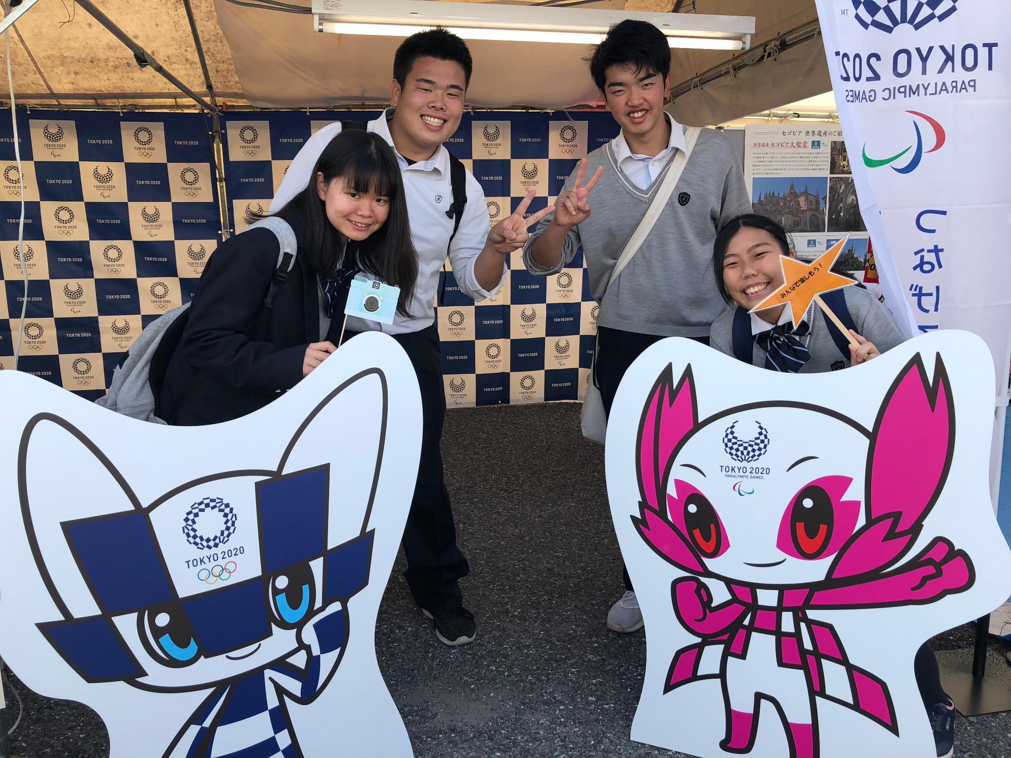 東京オリンピックマスコットのパネルが設置されたフォトスポットでポーズをする人たち