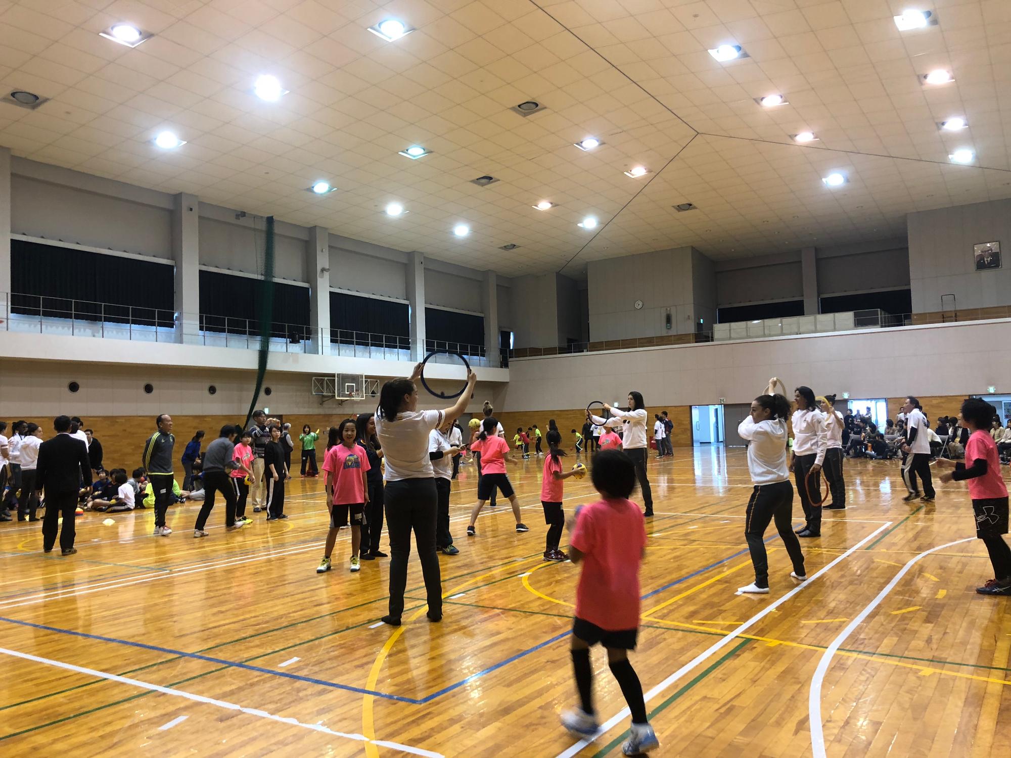 教室開催中の様子(体育館で練習する選手と参加者)