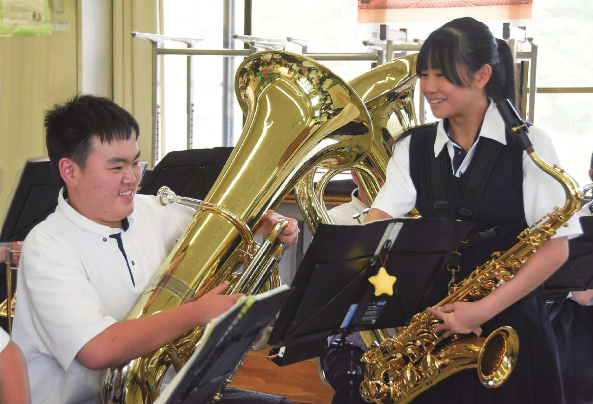 中学校の吹奏楽部の練習の様子。サックスパートの子がチューバパートの子に教えている様子