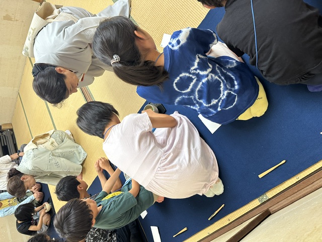 教えてもらいながら抹茶を点てている写真