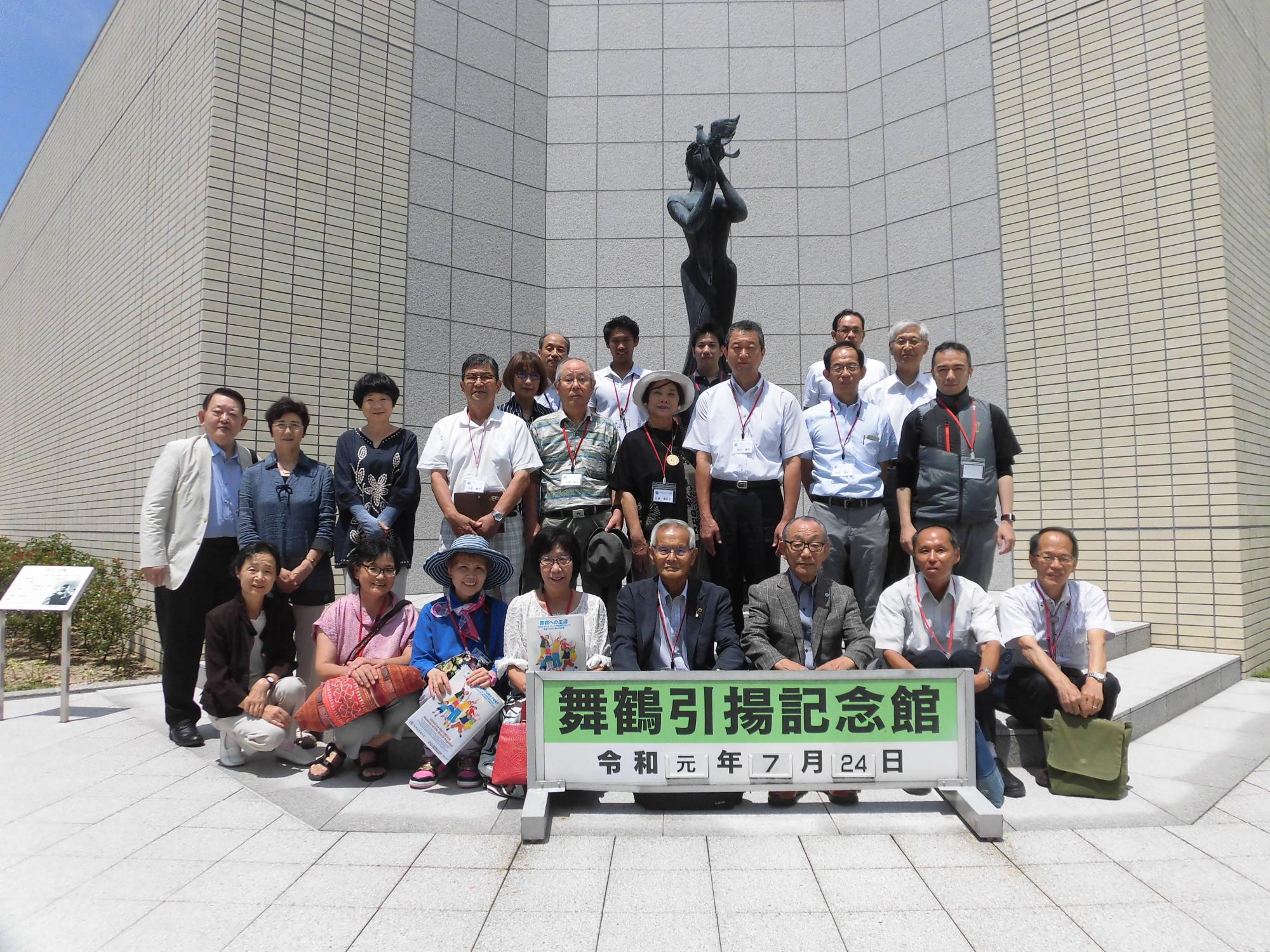 舞鶴引揚記念館の銅像の前で関係者の人達の集合写真