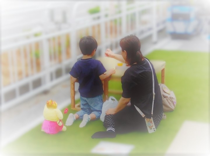 親子が人工芝で遊んでいる様子