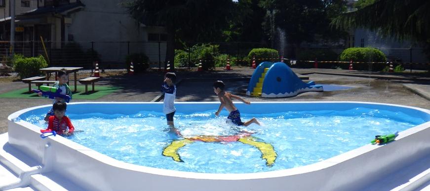 ひこにゃんの絵が描かれた外馬場公園水遊び場で子どもたちが遊んでいる写真