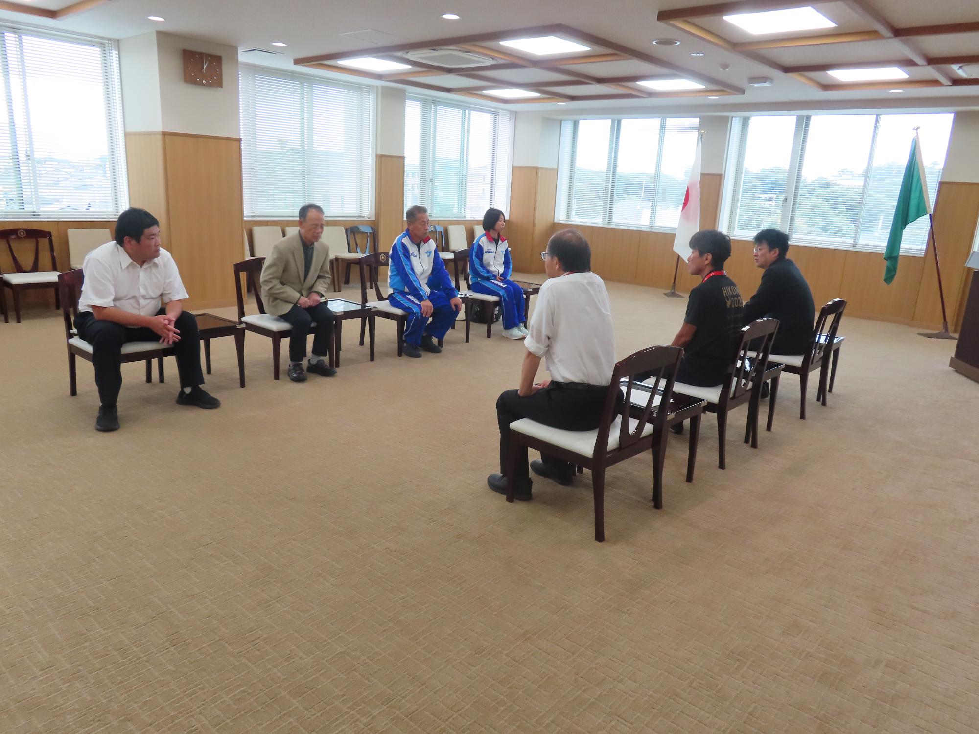 向かい合い歓談する選手たちと市関係者
