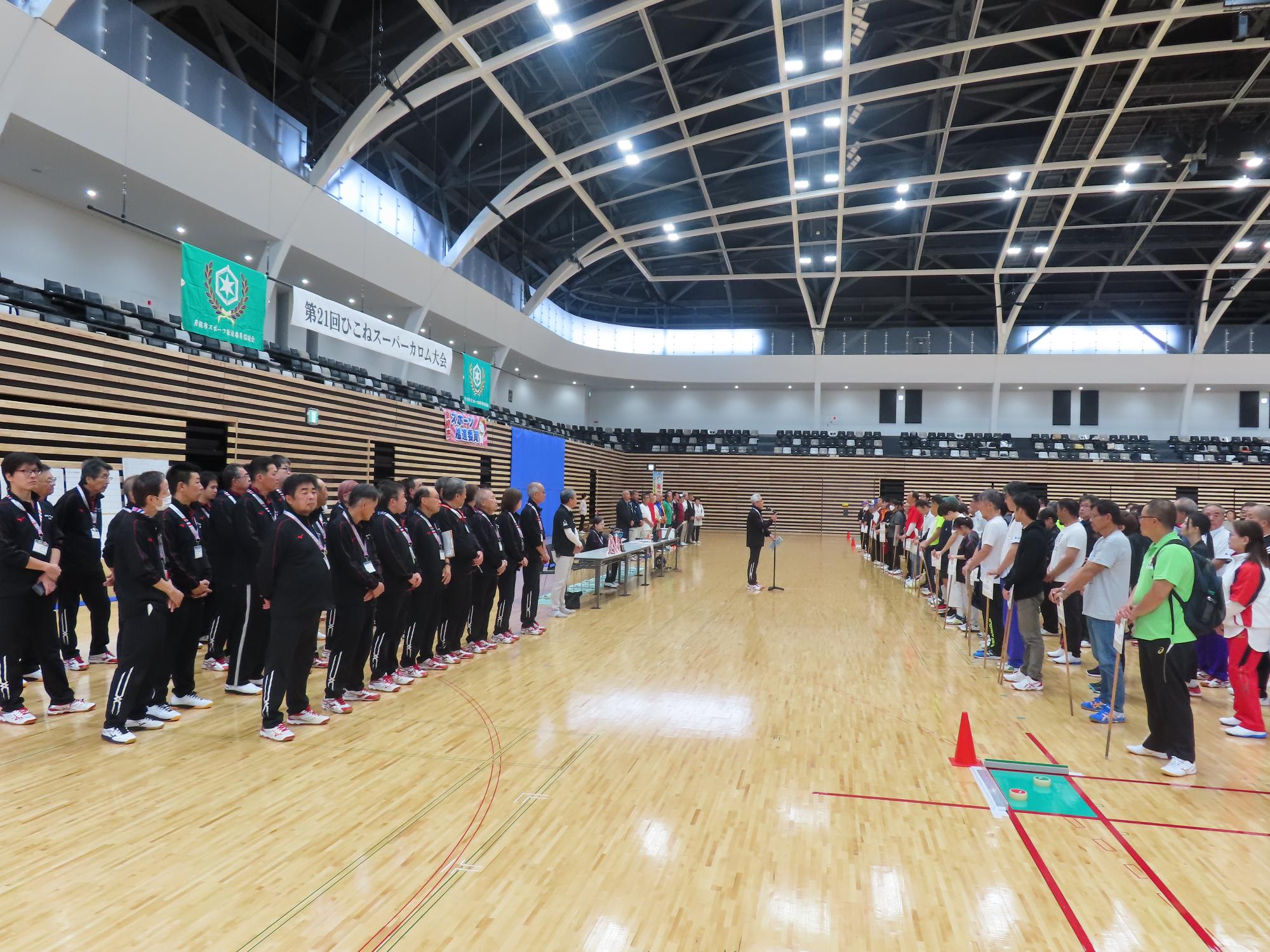 開会式の様子の写真（前に並ぶ役員とあいさつする人、参加者）