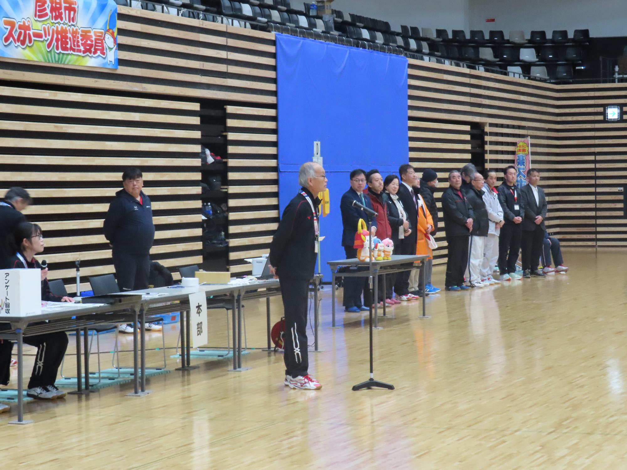 男性がマイクの前に立ち挨拶している写真