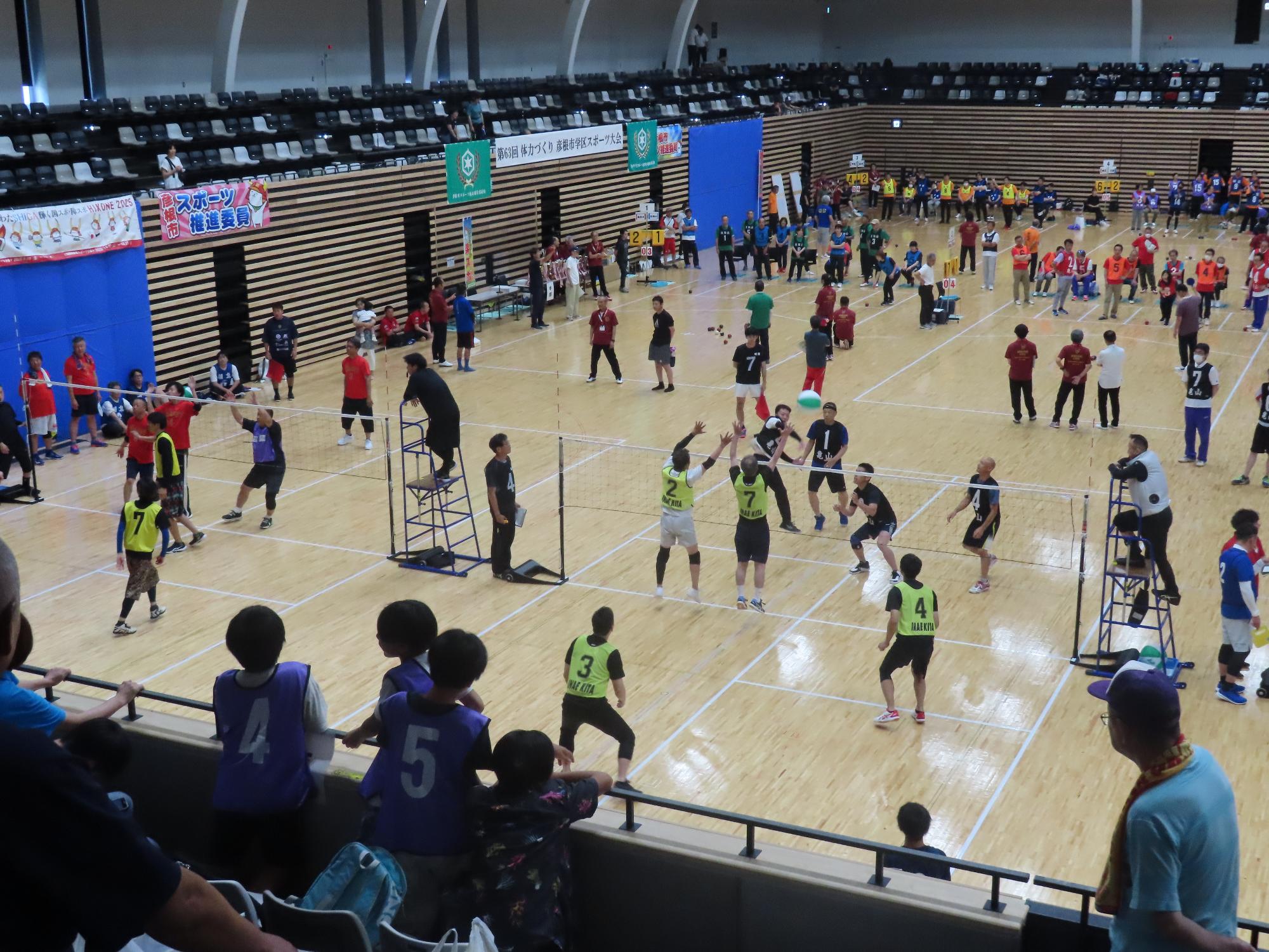 男子チームがビーチボールの試合をしている様子の写真