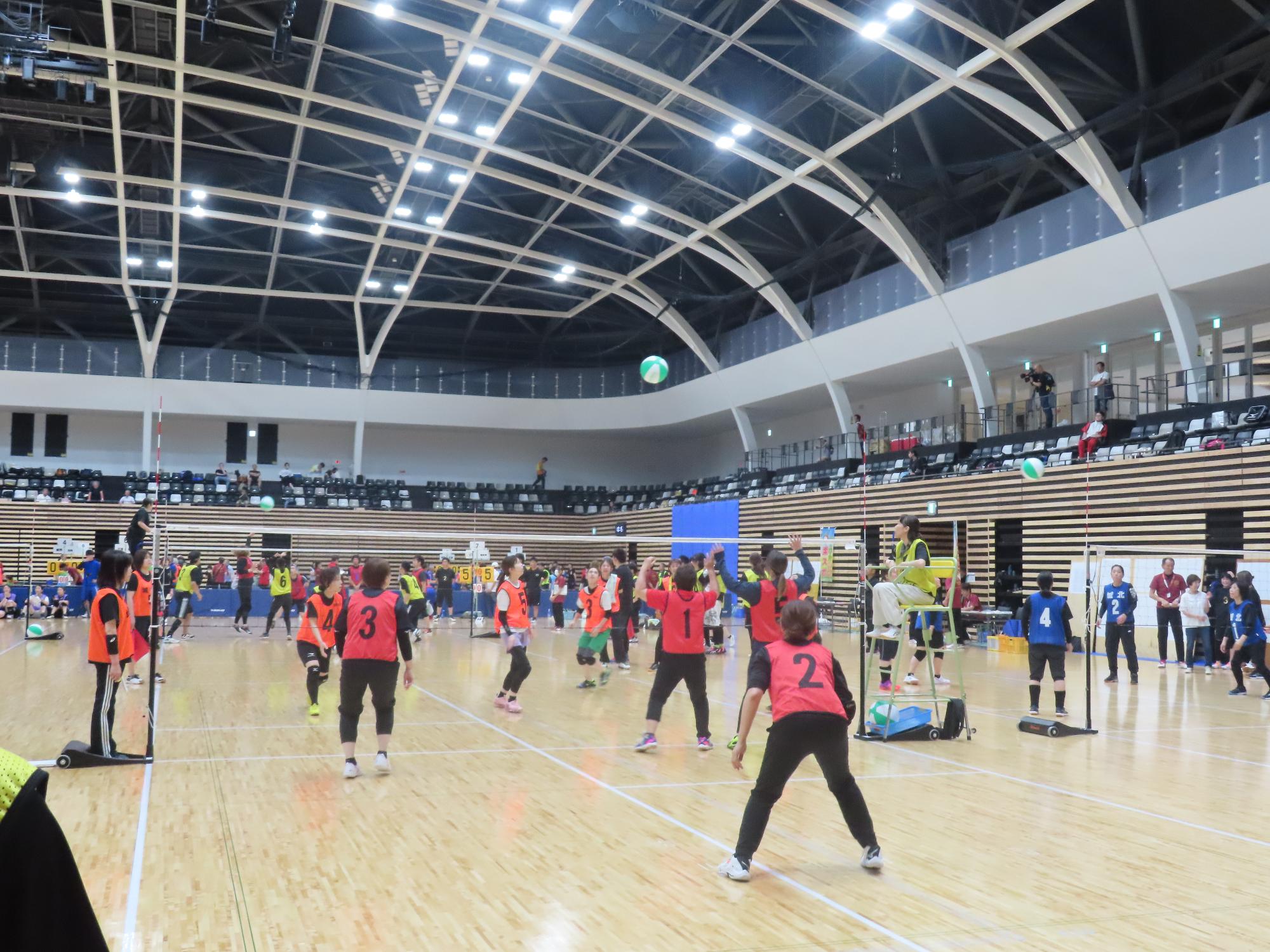 女子チームがビーチボールの試合をしている様子の写真