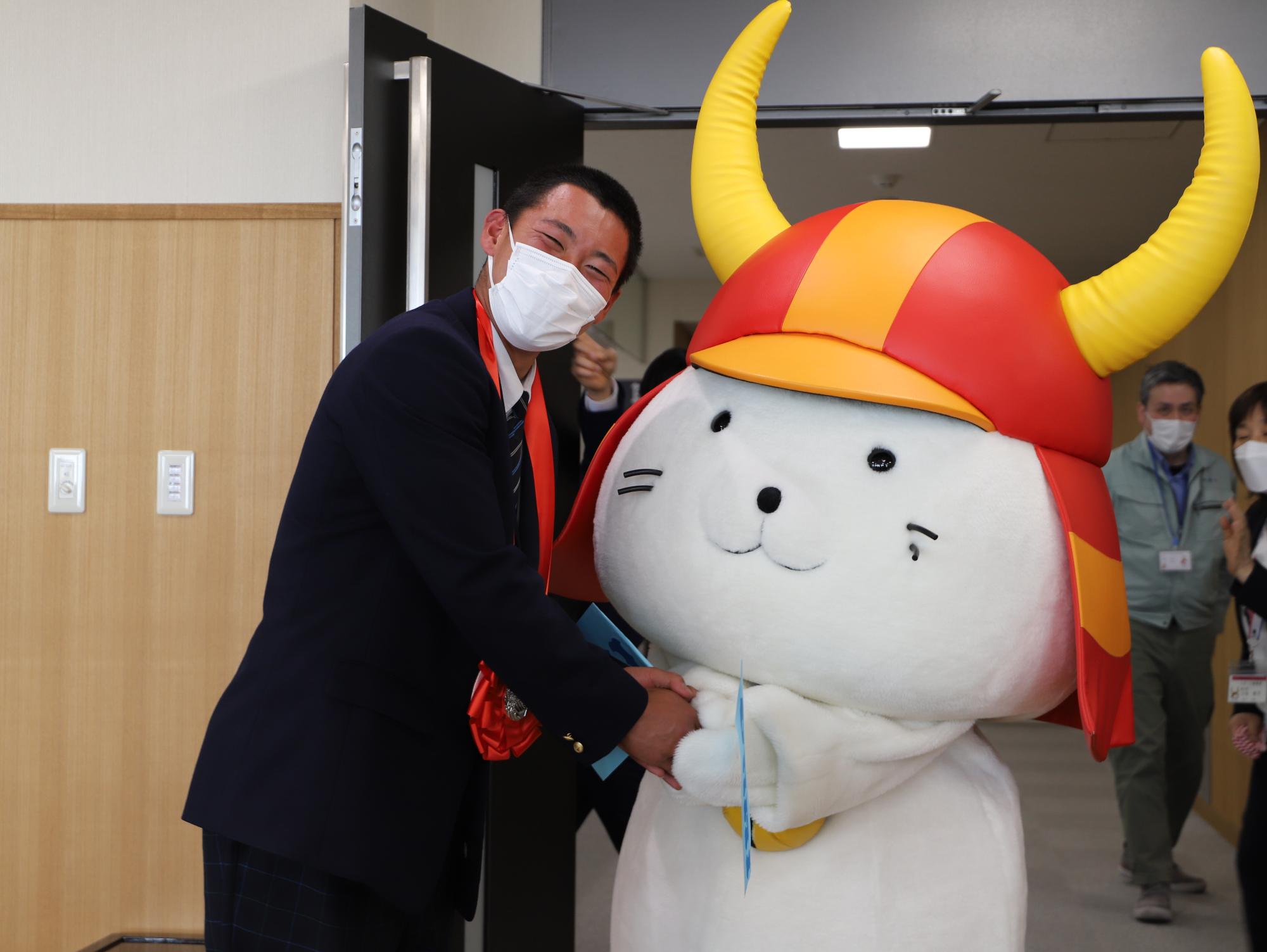 ひこにゃんと選手が握手している写真