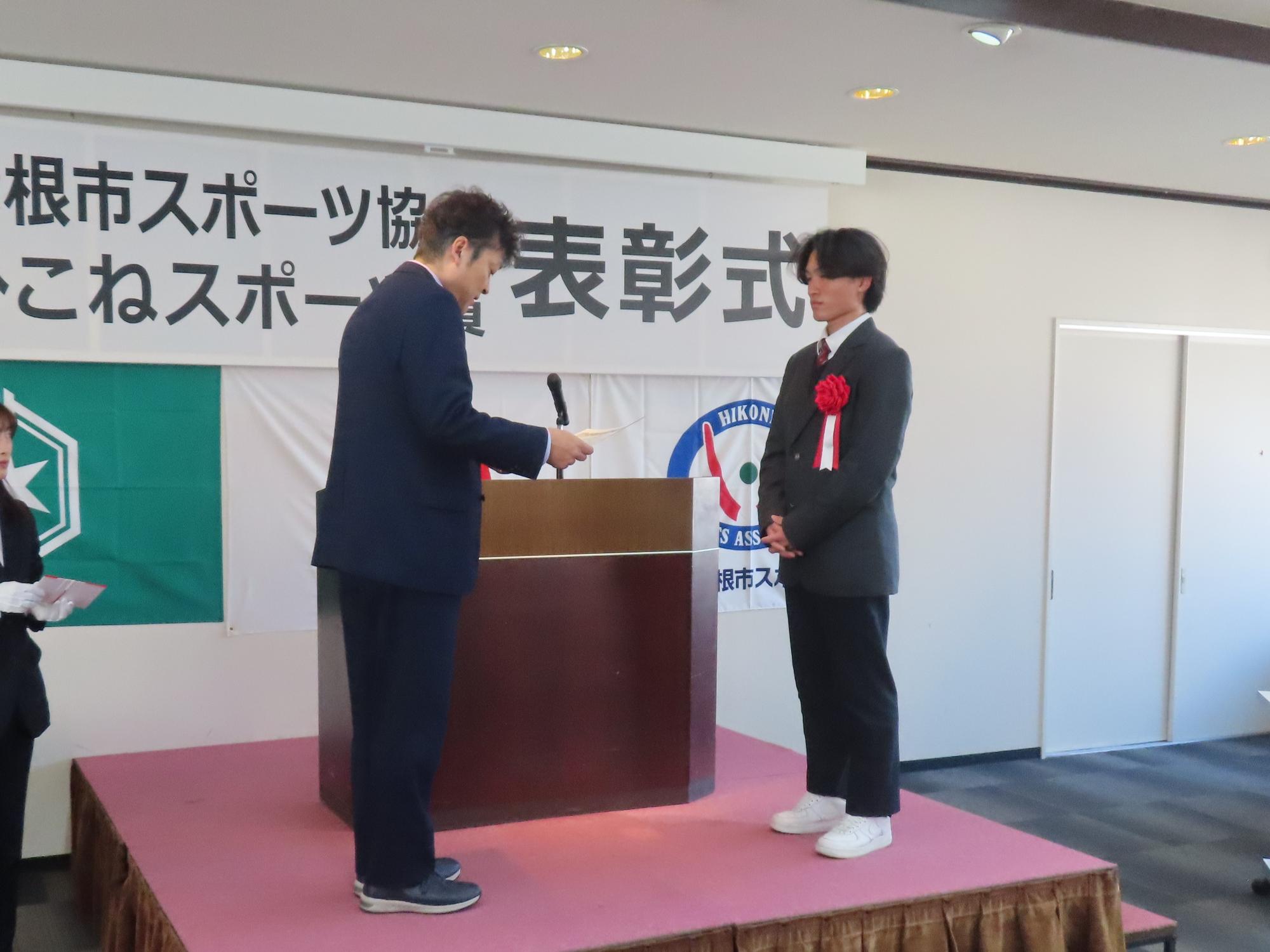 眞田くんが表彰状を受け取るところの写真