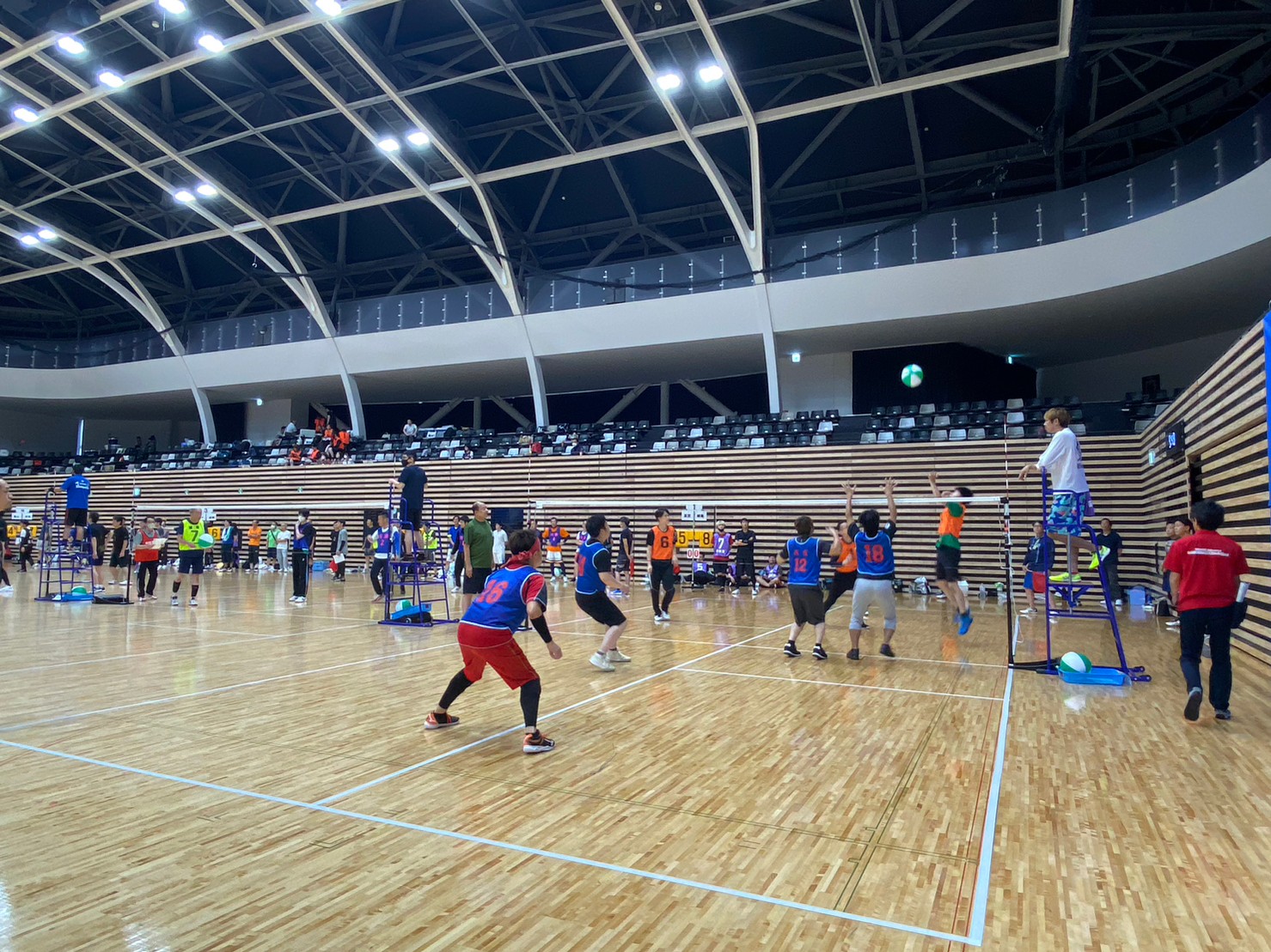 男子チームがビーチボールの試合をしている様子の写真