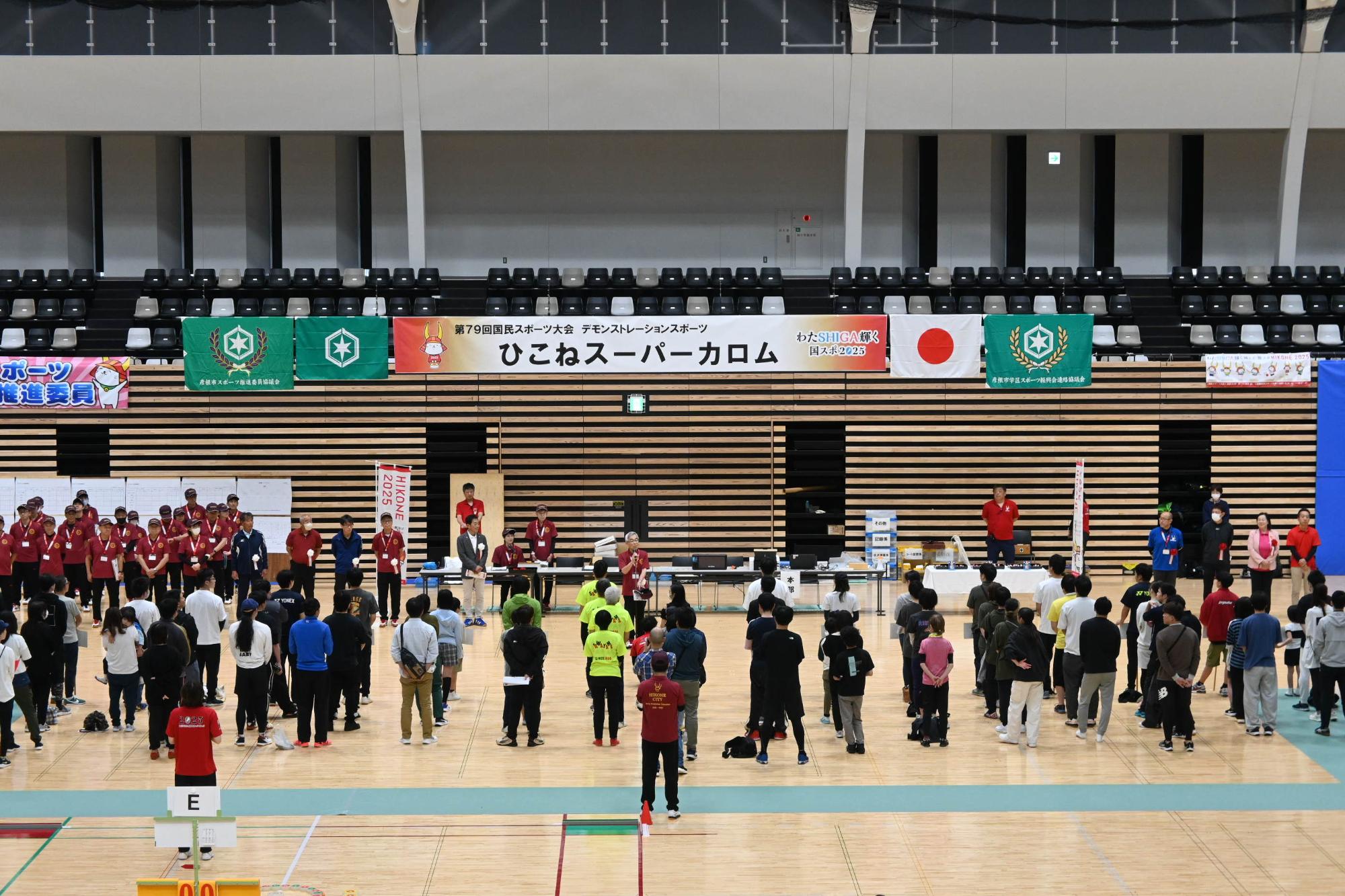 開会式の様子の写真（体育館で参加者たちが整列している）