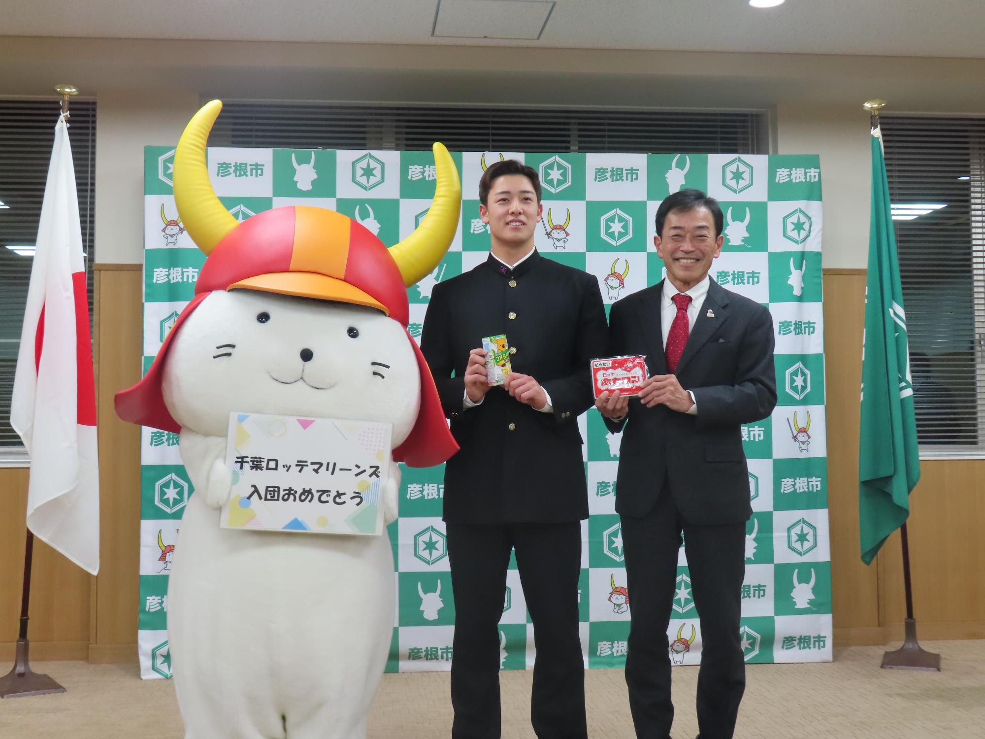 奥村選手、市長とひこにゃんがならんで写真撮影