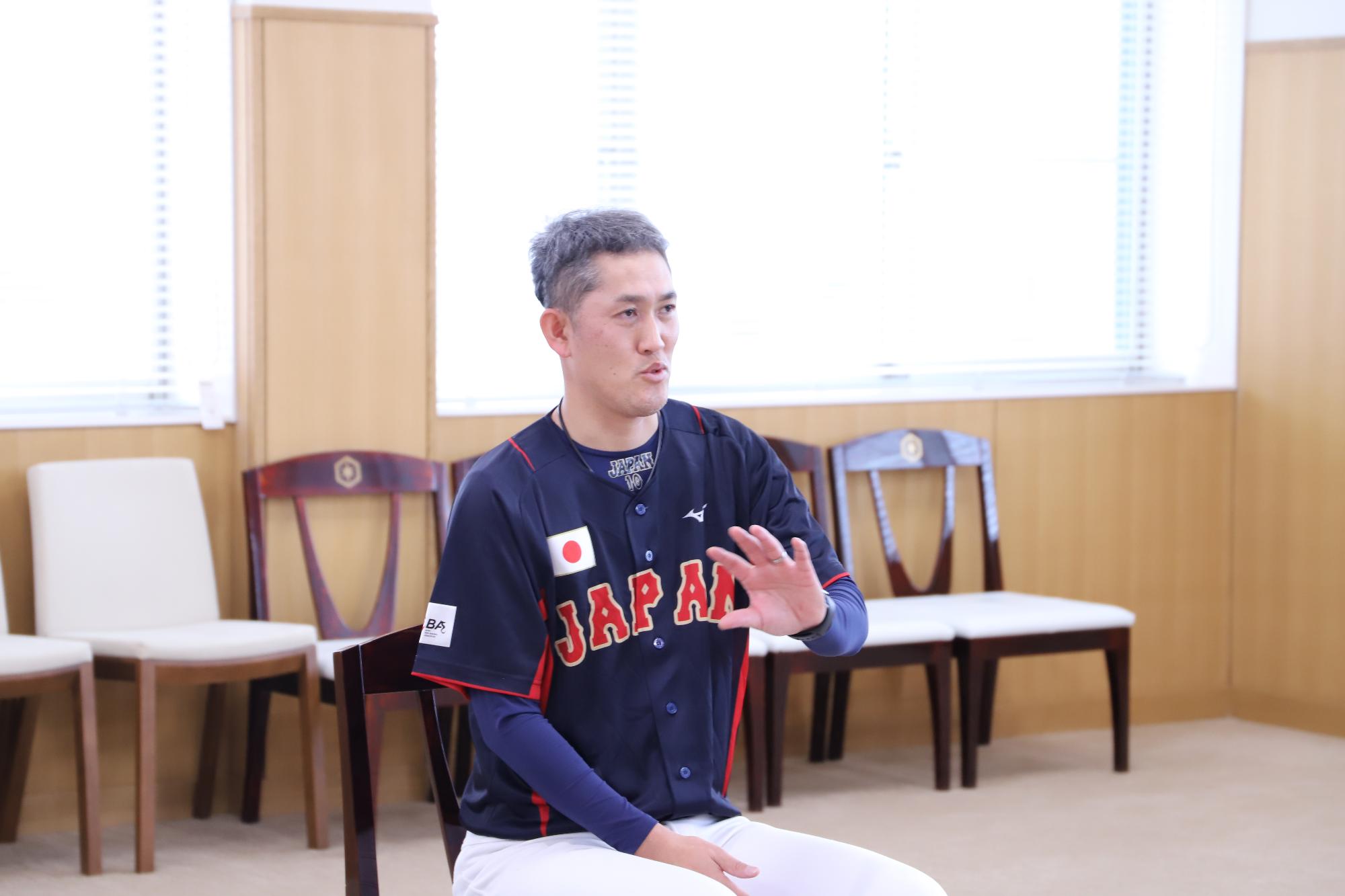 椅子に座って話す森豊選手の写真