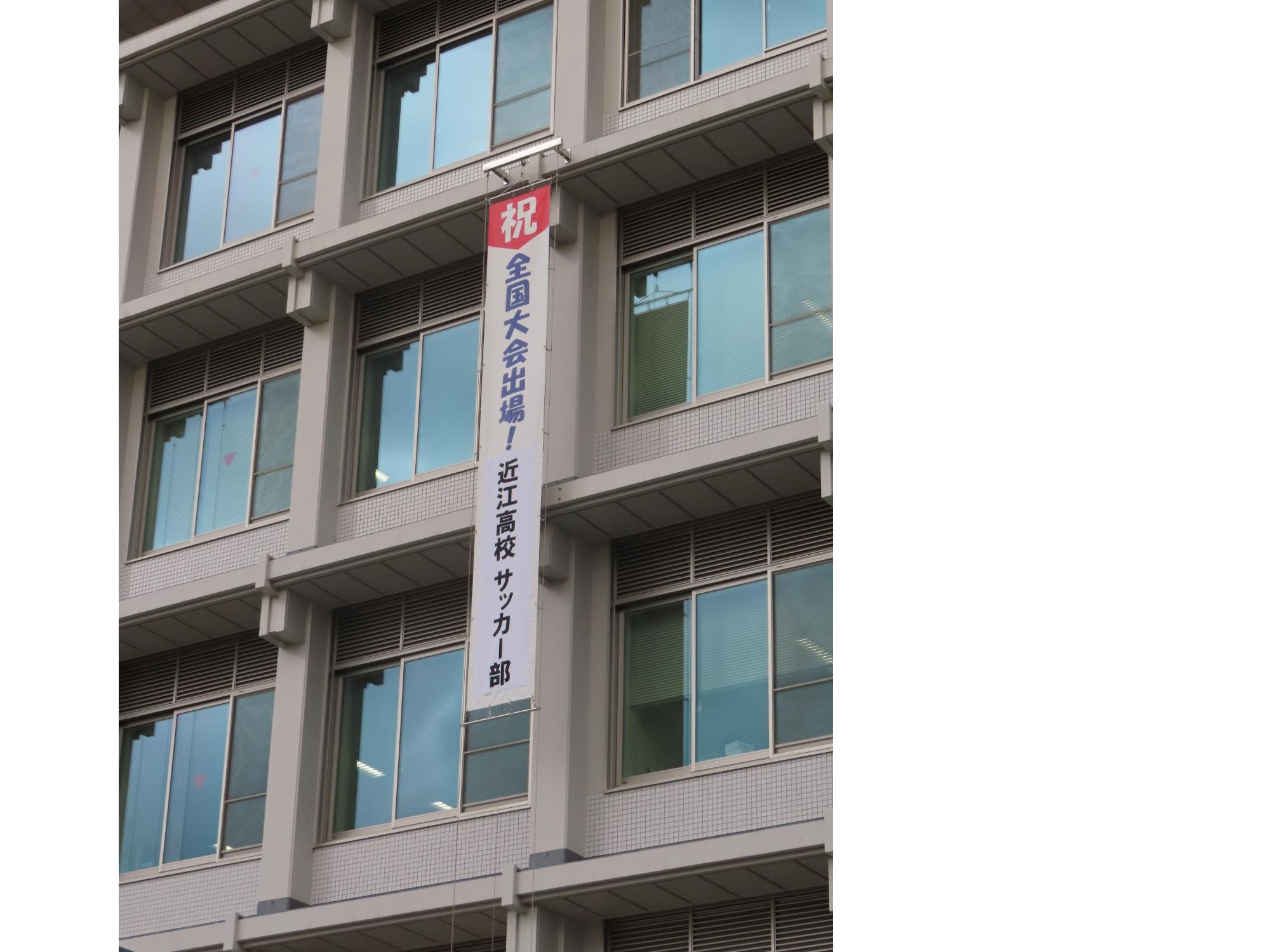 市役所本庁舎壁面に掲出された懸垂幕「祝全国大会出場！近江高校サッカー部」