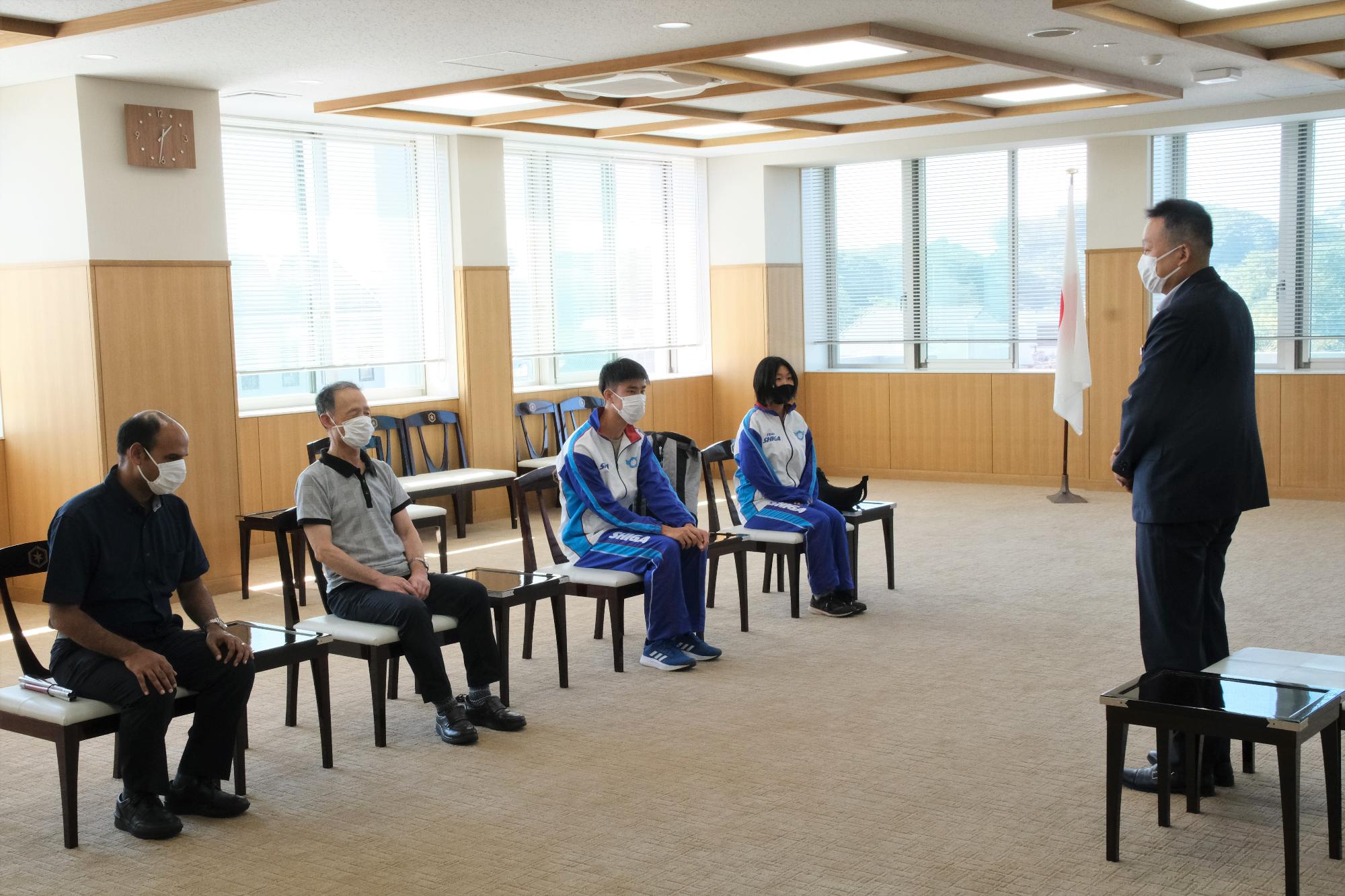 挨拶する彦根市長と向かい合い座る選手たちの写真
