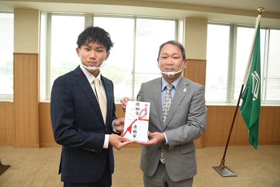 激励金をもつ副市長と山本さんの写真
