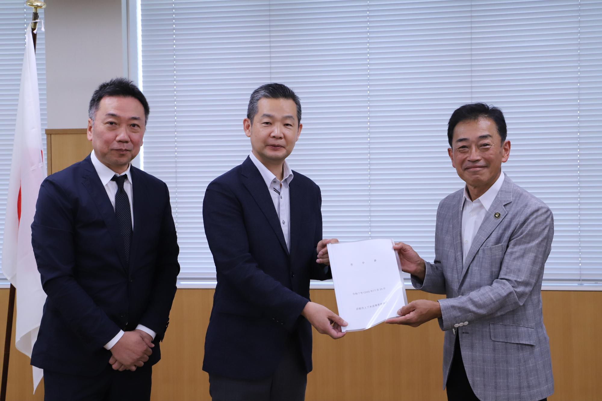 答申書を手にもつ審議会のメンバーと市長