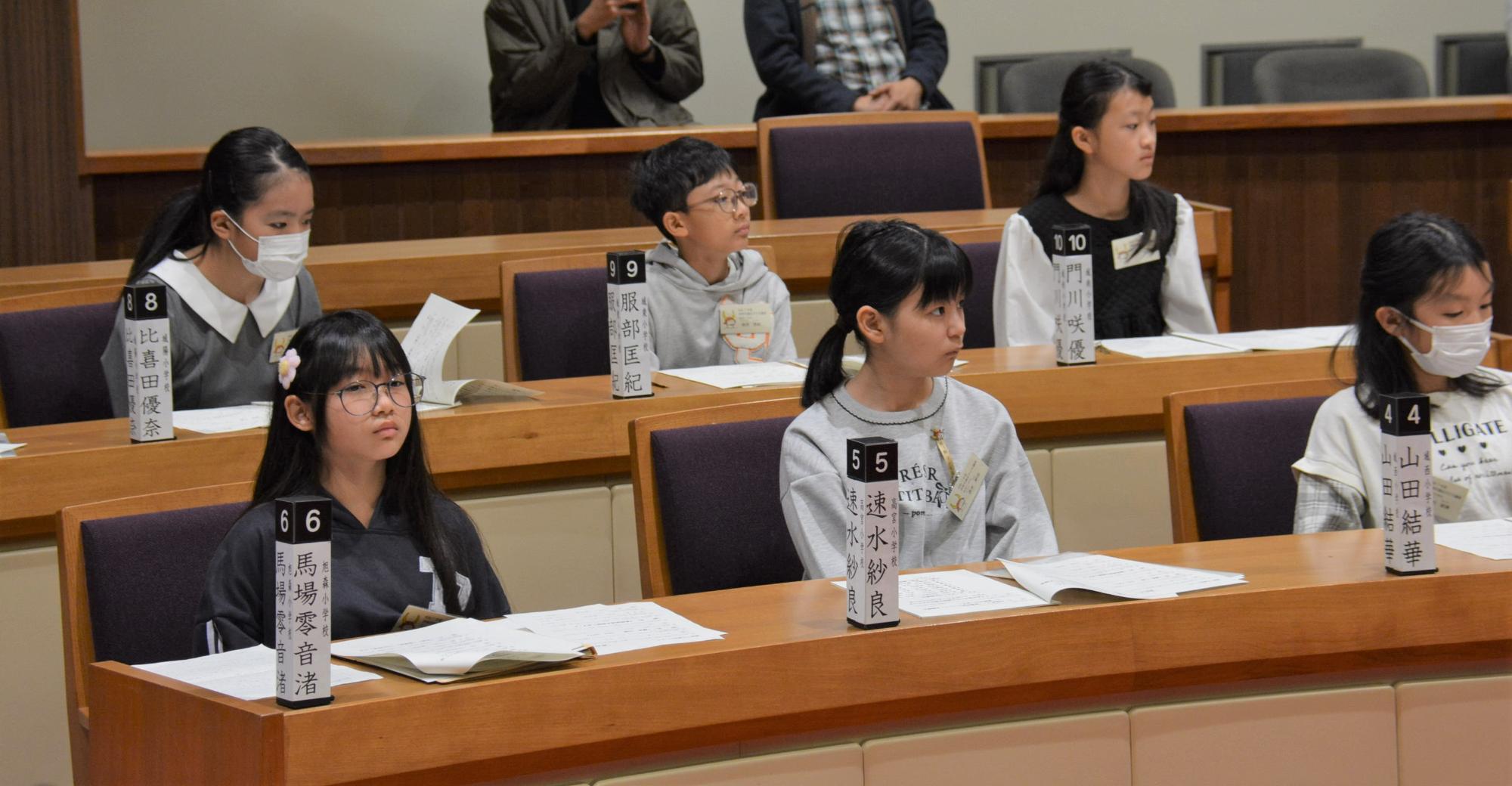 議場で席に座り説明に耳を傾ける子どもたちの様子