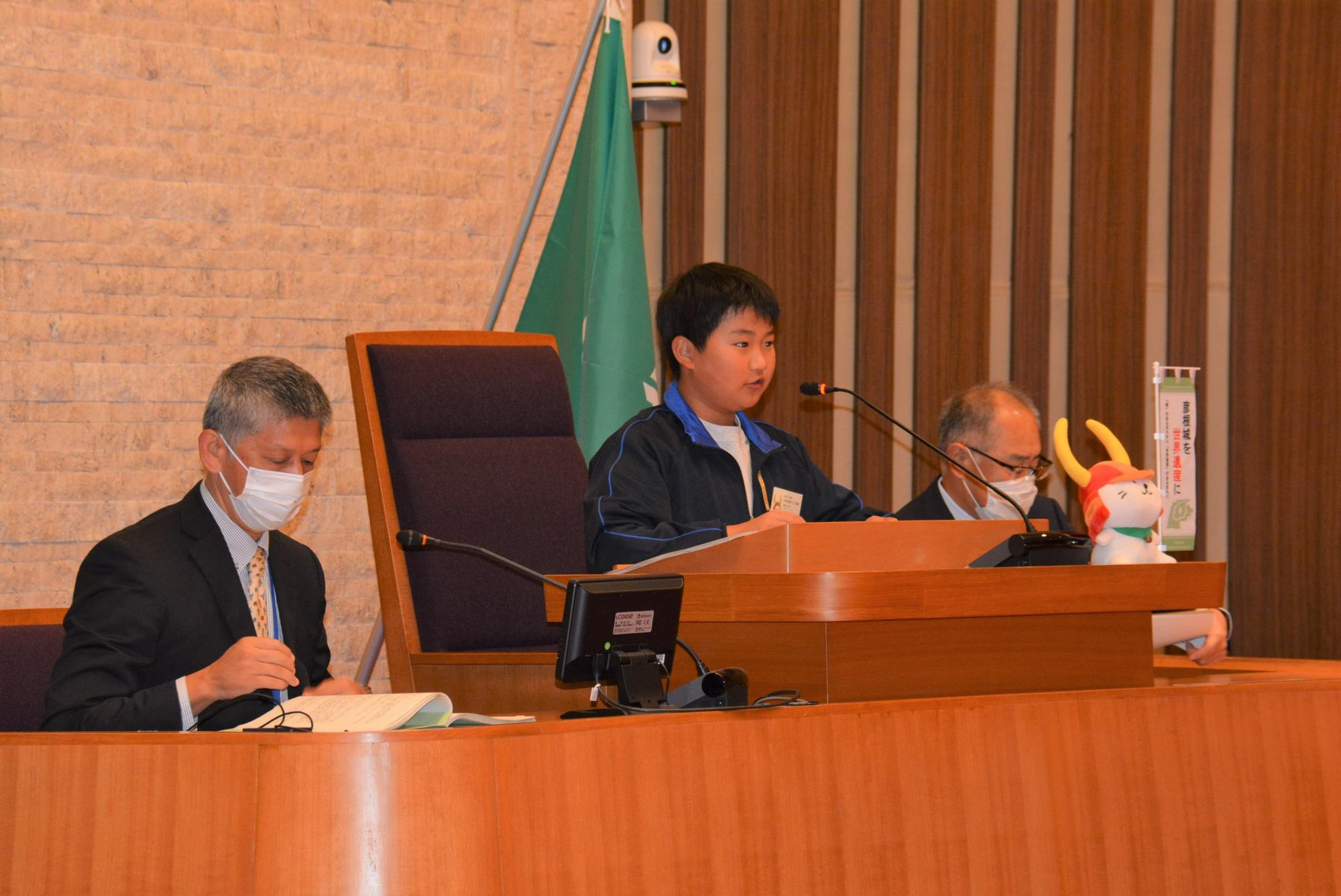 マイクに向かってしゃべる子どもの画像