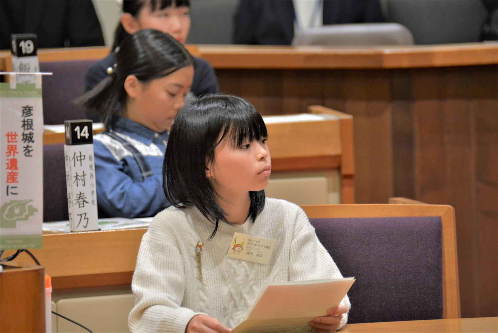 資料を持ち話を聞いている子供の様子の画像