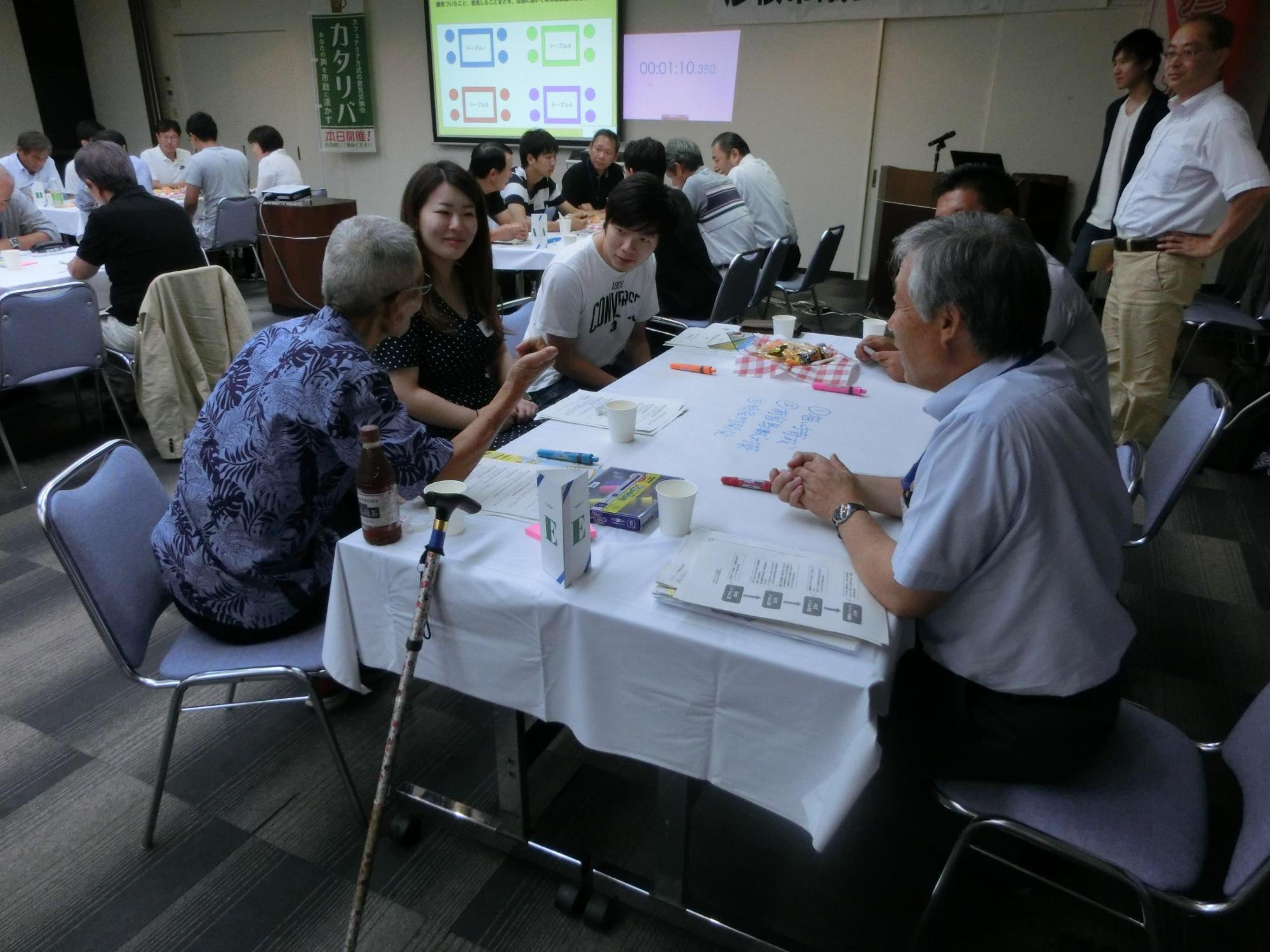 年配の男性が学生さんに話かけている写真