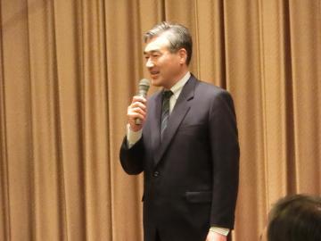 新年会会場でお祝いのことばを述べる市長の写真