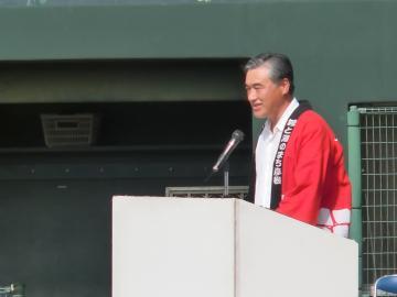 赤い法被を着て開会式で挨拶をする市長の写真