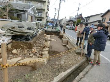 礎石を説明を受けながら確認する市長の写真