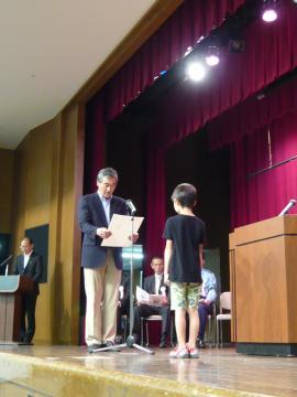 表彰式で入賞者の児童に表彰状を読み上げる市長の写真