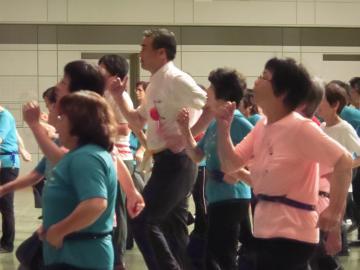 交流タイムウォーミングアップで参加者と一緒に体操をしている市長の写真
