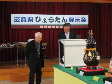 展示会でひょうたんを見学している市長の写真